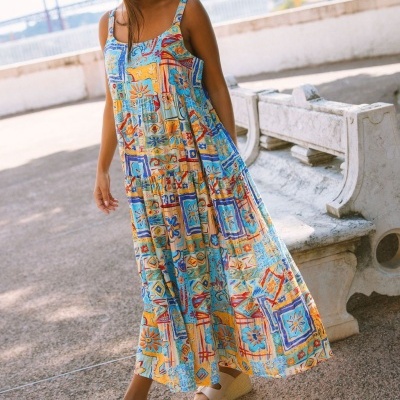 Vestido longo colorido com sandálias e chapéu de palha ao ar livre
