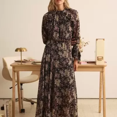 Vestido longo de tecido com padrão floral escuro e sapatos bordô no escritório