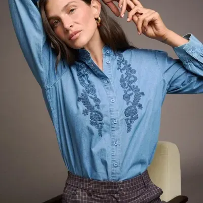 Camisa azul bordada e calças xadrez