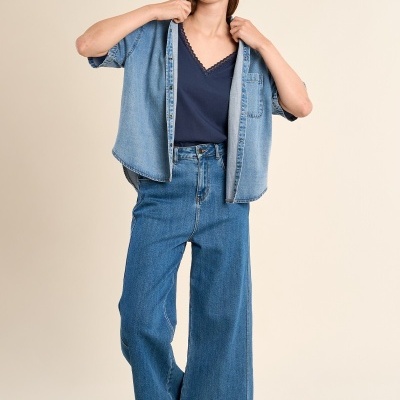 Mulher com roupa casual jeans e sandálias em fundo bege