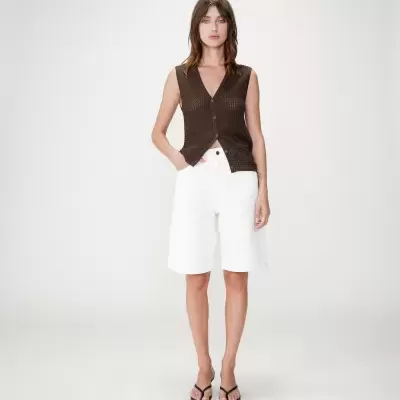 Mulher com colete castanho e calções brancos dianteira