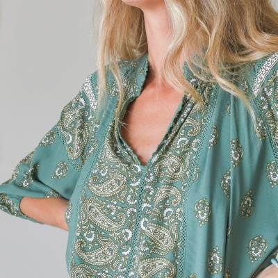Blusa verde com padrão floral e paisley, decote em V e detalhes em renda.