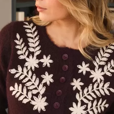 Blusa de malha castanha com botões e bordados brancos de flores e folhas