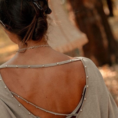 Camisola cinza com decote e pérolas nas costas com cabelo preso