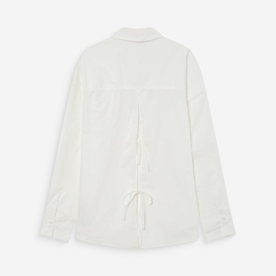 Camisa branca de manga comprida vista pelas costas com laços no centro.