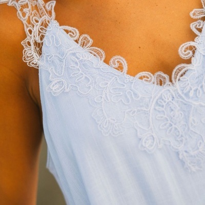 Vestido azul claro com renda branca detalhada no decote e alças
