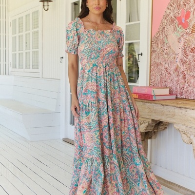 Vestido comprido com padrão floral em rosa, azul e bege com mangas curtas franzidas.