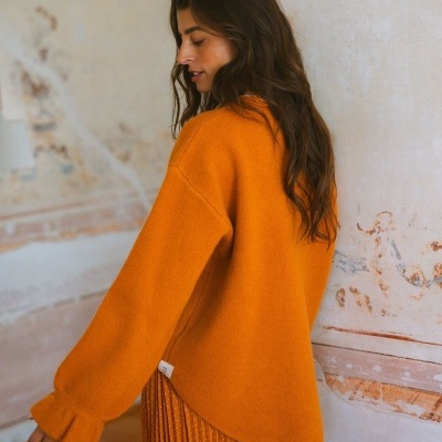 Camisola mostarda oversized com saia plissada laranja com pontos brancos