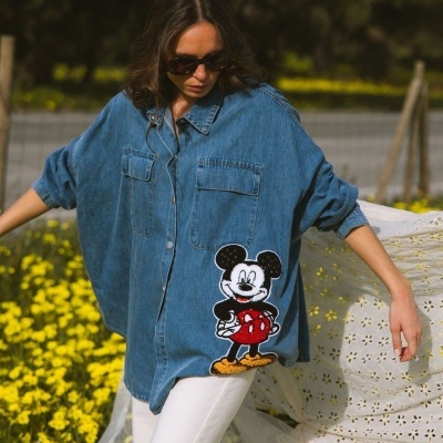 Blusão azul de ganga com estampa do Mickey Mouse usado por mulher