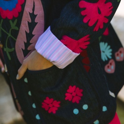 Casaco preto com flores bordadas multicoloridas e manga com dobra de camisa listrada