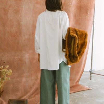 Pessoa de costas com roupa casual e casaco peludo castanho