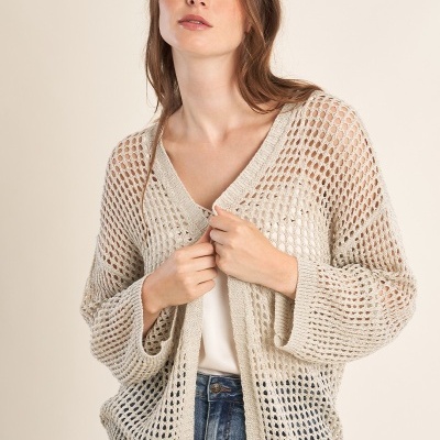 Casaco de malha bege claro com padrão de buracos usado por mulher
