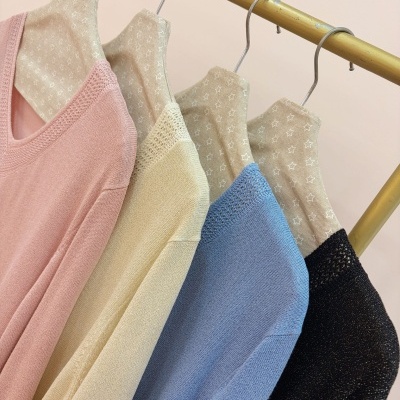 Camisolas de malha coloridas penduradas em cabides dourados