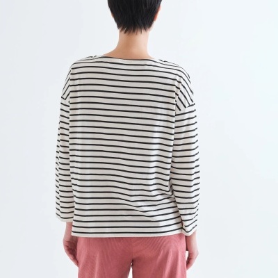 Pessoa de costas com camisola às riscas e calças rosa.