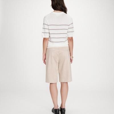 Mulher de costas com camisola branca listrada e calções bege