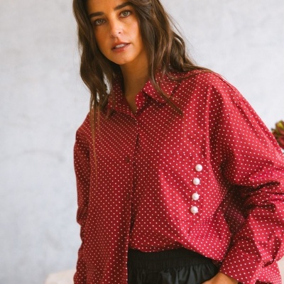 Camisa vermelha com pontos brancos e botões de pérola decorativos na lateral