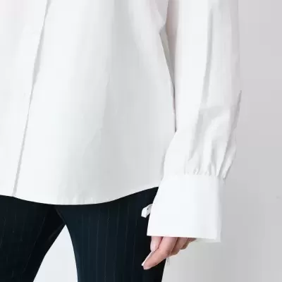 Camisa branca de algodão com botões e calças pretas riscas finas.