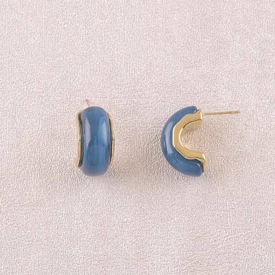 Brincos de argola semicircular azuis com detalhes dourados num fundo bege
