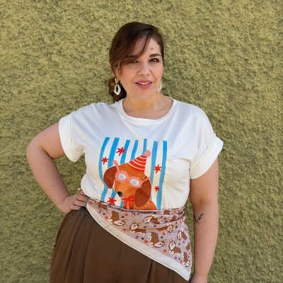 Mulher com t-shirt com desenho de cão e lenço bege com padrão de cães