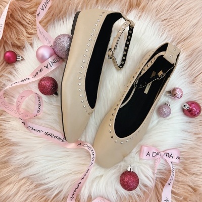 Sapatilhas bege com tachas e tiras, fitas rosa e bolas de natal