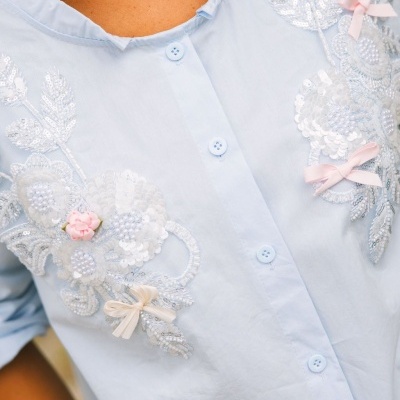 Camisa feminina azul claro com bordados florais e botões