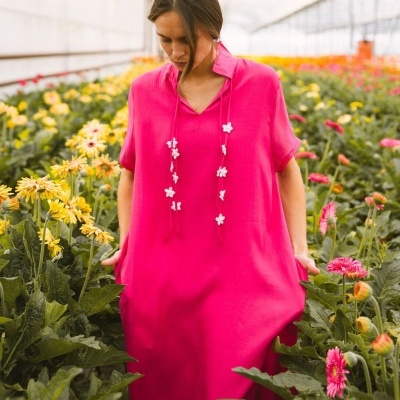 vestido longo rosa vibrante com flores brancas e bolsos