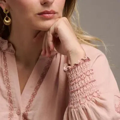 Blusa rosa clara com bordados e punhos franzidos usada por mulher