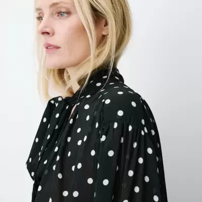 Blusa preta com bolinhas brancas, vista lateral