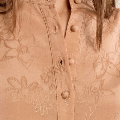 Blusa rosa claro com padrão floral, botões revestidos e gola com pregas