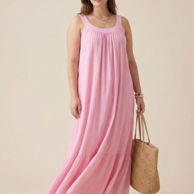 Vestido longo rosa claro com alças largas, sandálias rosas e bolsa de palha