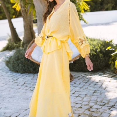 Vestido amarelo claro com mangas longas e renda usadas por mulher ao ar livre