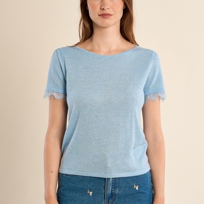 Mulher com t-shirt azul clara e calções de ganga bordados