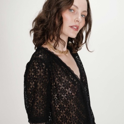 Blusa feminina preta de renda com padrão floral e mangas médias