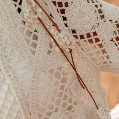 Tecido branco em croché com padrão floral e detalhes em cordão castanho