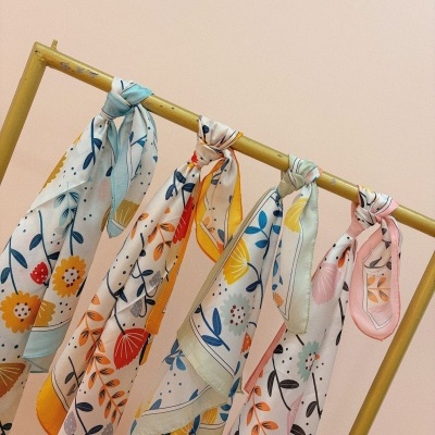 Lenços florais coloridos pendurados num suporte metálico amarelo