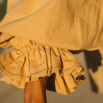 Detalhe de vestido ou saia amarela com punho franzido elástico