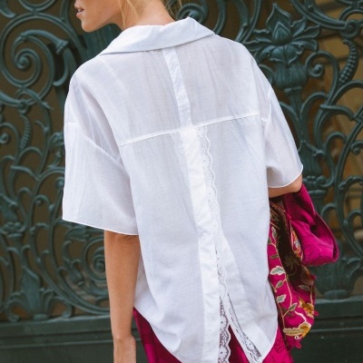 Camisa branca feminina com detalhe de renda nas costas e saia rosa-magenta estampada