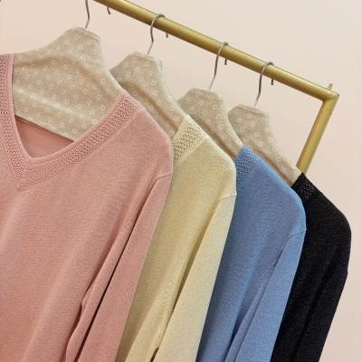 Camisolas de malha pastel em cabides com padrão de estrelas.