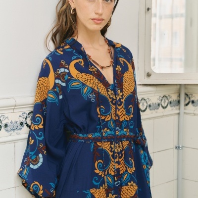 Vestido azul com padrão floral e de pavões amarelos e azuis
