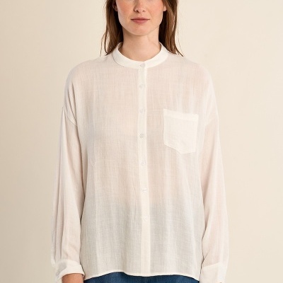 Blusa branca feminina transparente com bolso e botões, usada com calças de ganga azuis