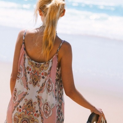 Vestido estampado leve com alças finas, vista de costas, fundo praia e mar