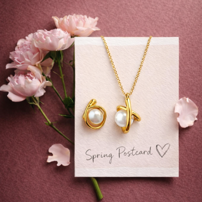 Colar e anel dourados com pérolas sobre cartão com flores cor-de-rosa e fundo rosa