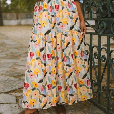 Saia longa floral colorida com cós elástico usada com camisa azul e sapatos castanhos