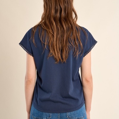 T-shirt azul escura e calças de ganga vistas de costas.