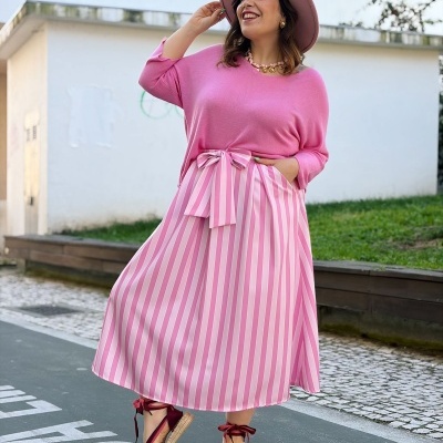 Mulher com roupa e acessórios rosa em ambiente urbano exterior