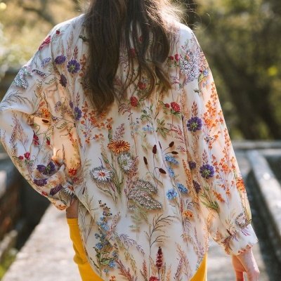 Blusa creme com padrão floral colorido vista de costas