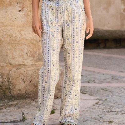 Calças compridas femininas com padrão floral azul e verde em fundo creme