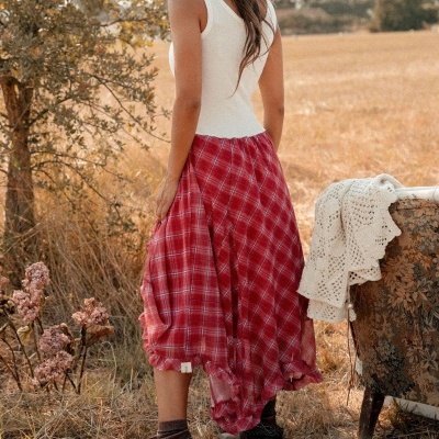 Saia midi xadrez vermelha com top branco e botas, campo seco, cadeira com manta croché