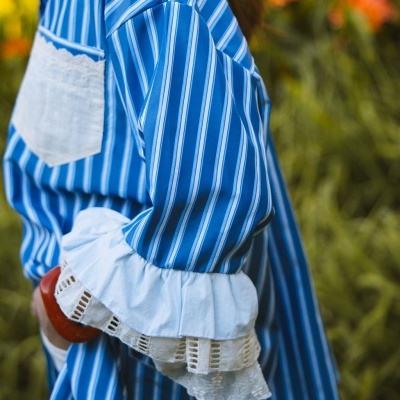 Blusa azul com riscas brancas e punhos brancos rendados