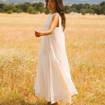 Vestido comprido branco com bordado floral usado em campo aberto